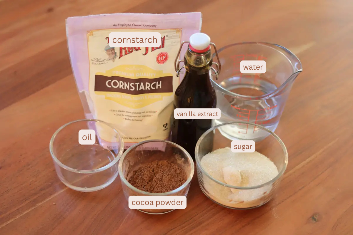 Labeled ingredient photo for the frosting. Includes oil, cornstarch, cocoa powder, vanilla extract, sugar, and water. 