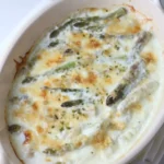creamed asparagus with parmesan cheese in a white dish.