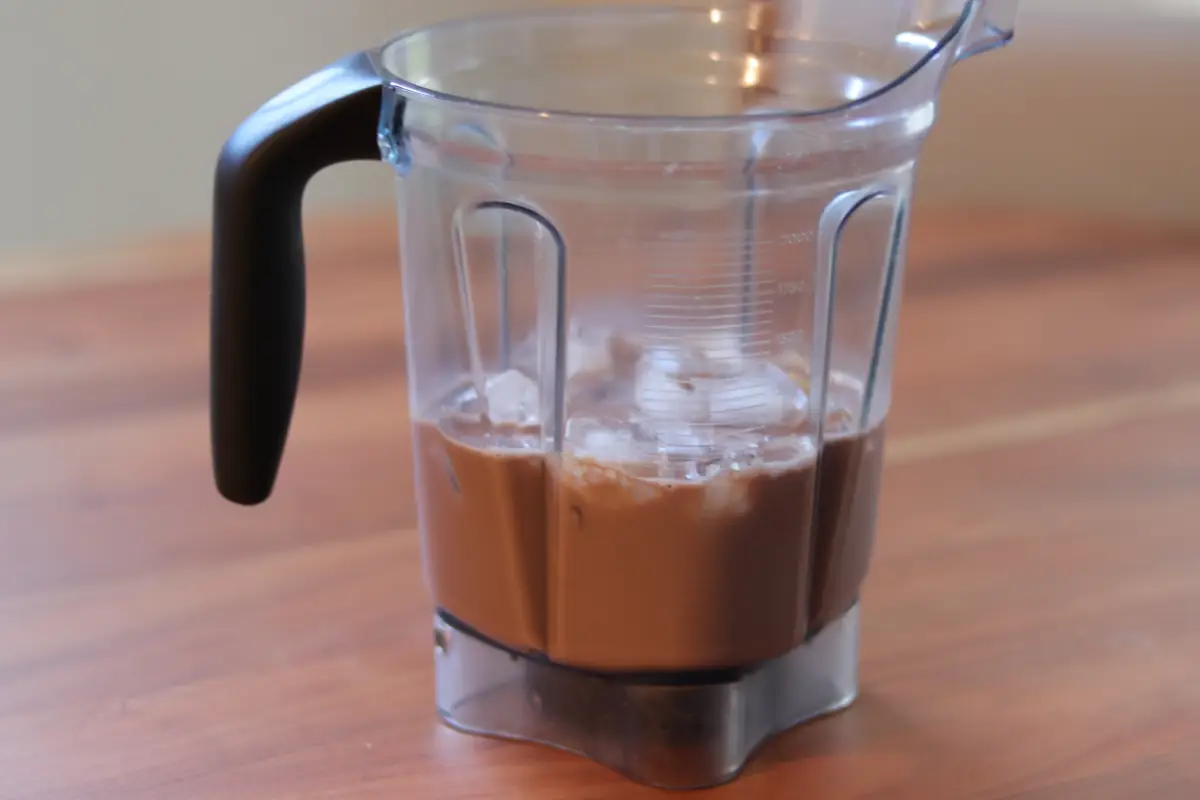 Chocolate milk, peanut butter, banana, and ice in a blender. 