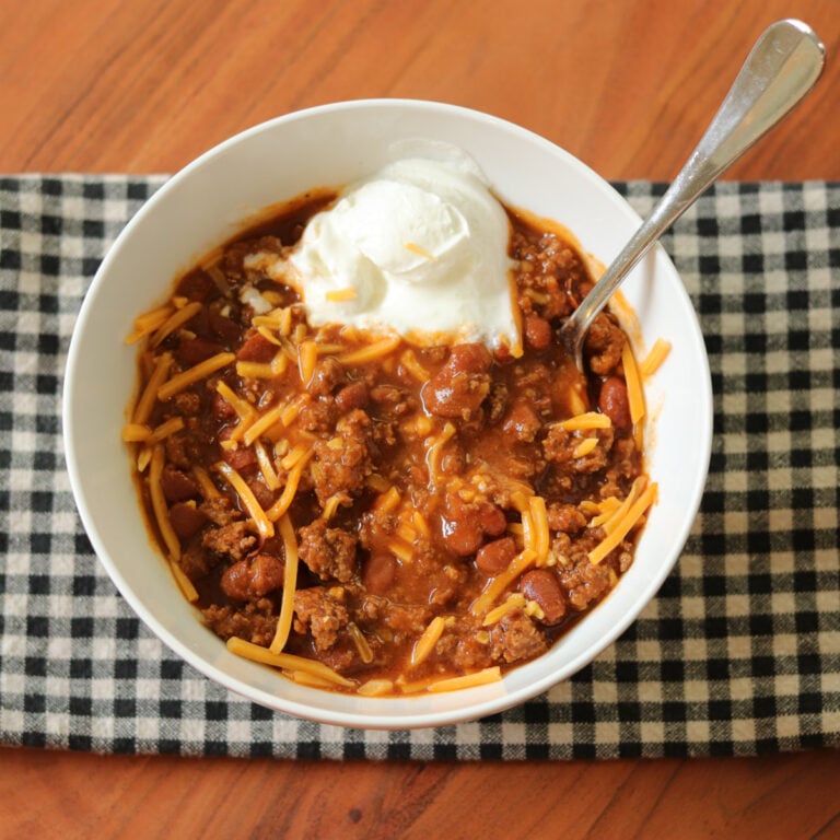 4 ingredient chili served in a bowl with sour cream and cheese.