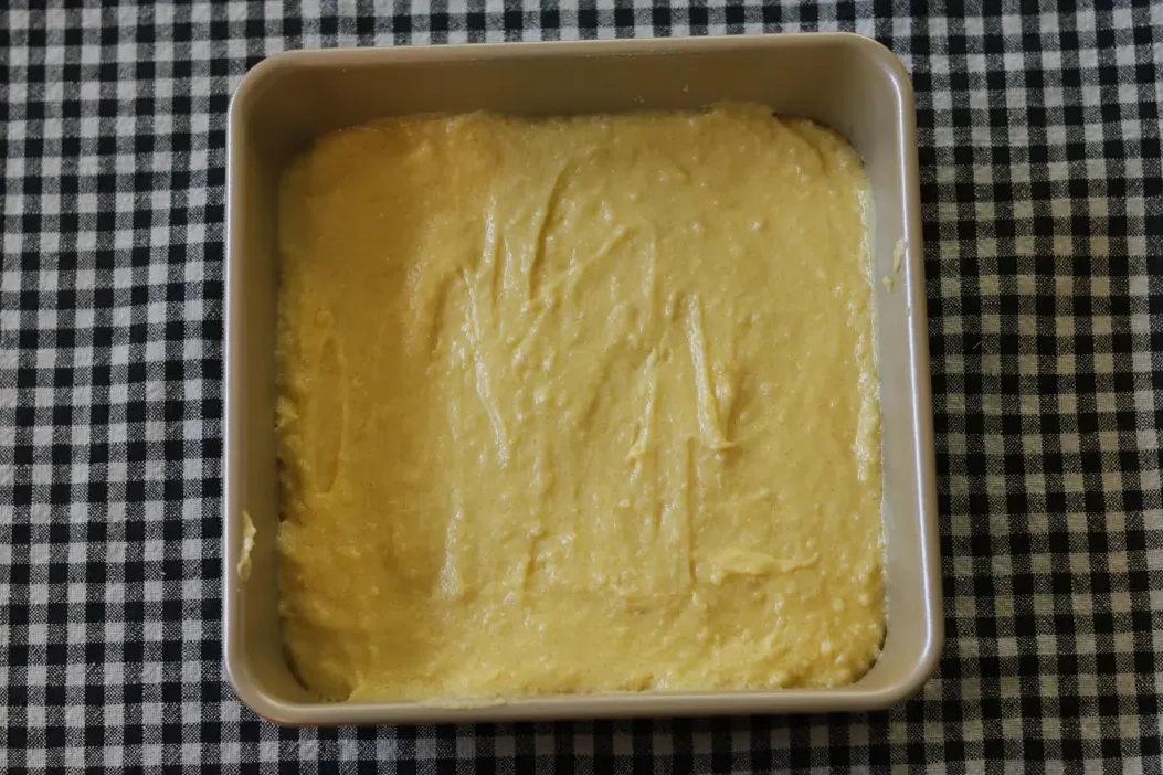 Lemon brownie batter spread into the baking dish.