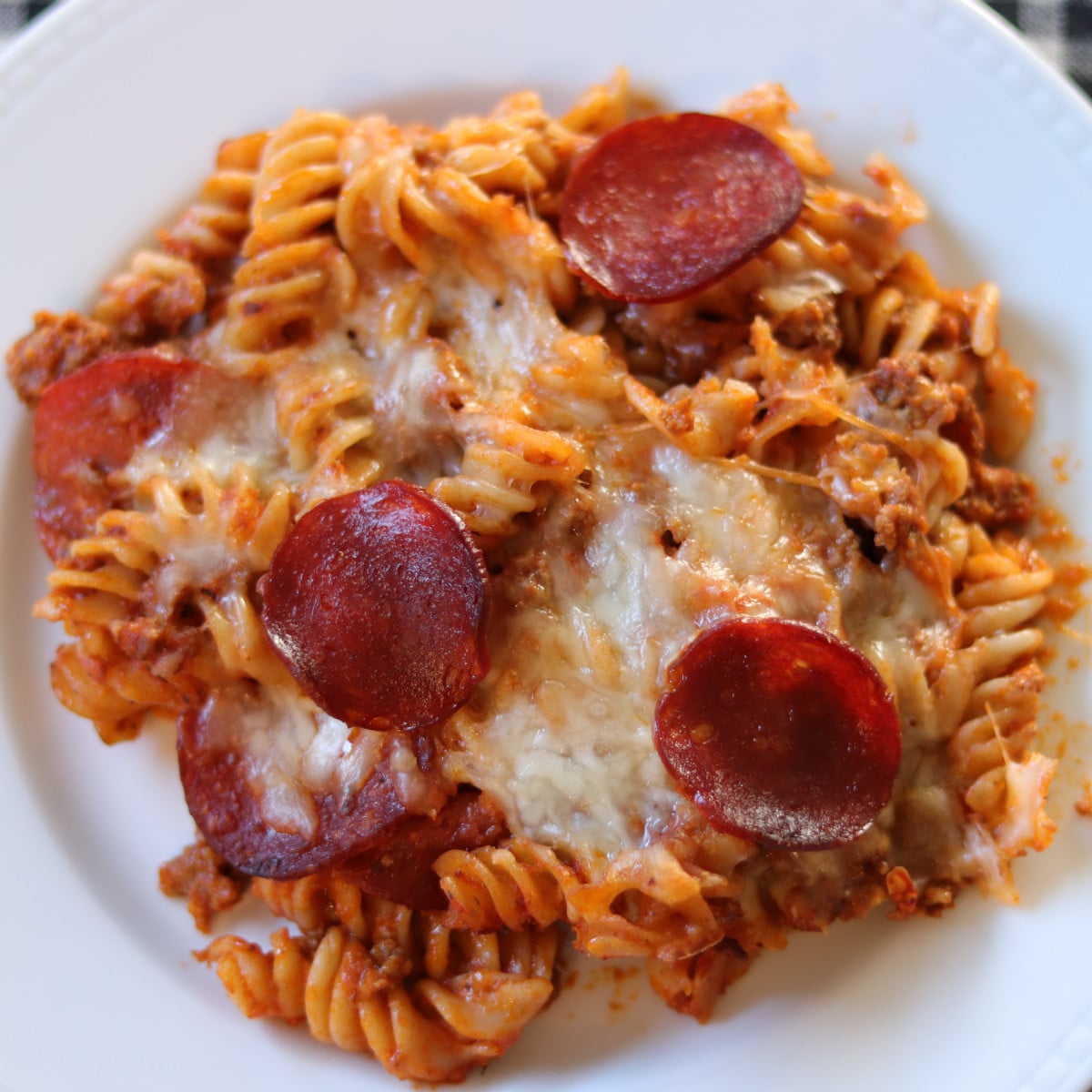 Pizza pasta casserole served on a white plate.