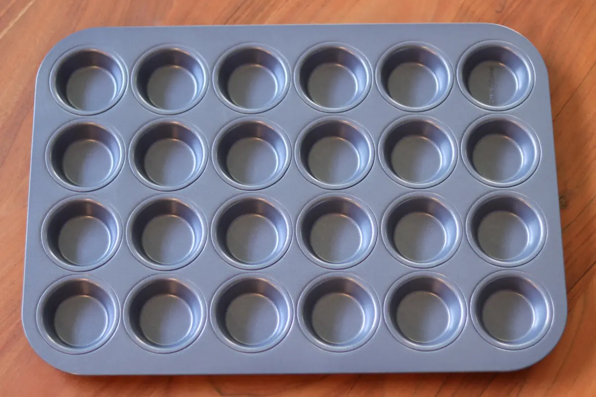 Empty mini muffin tin that has been greased.