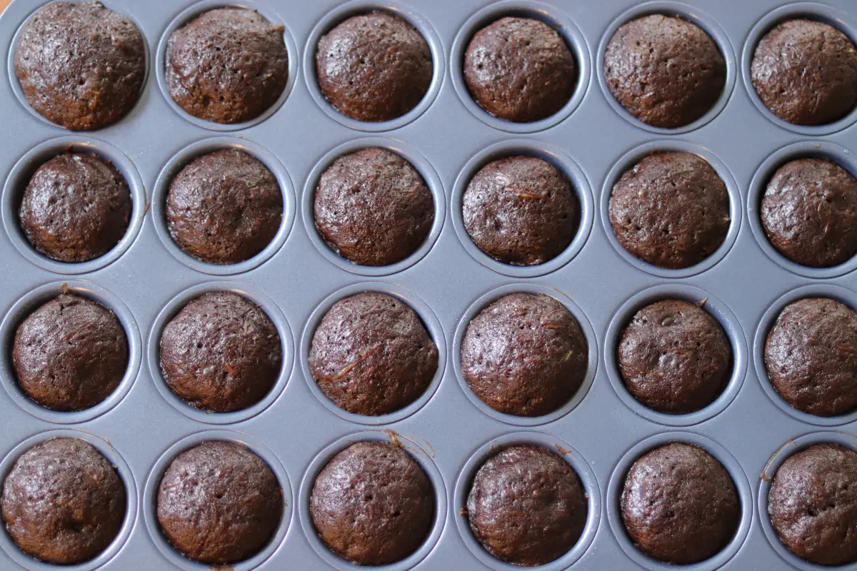 Baked zucchini mini muffins in the muffin tin.