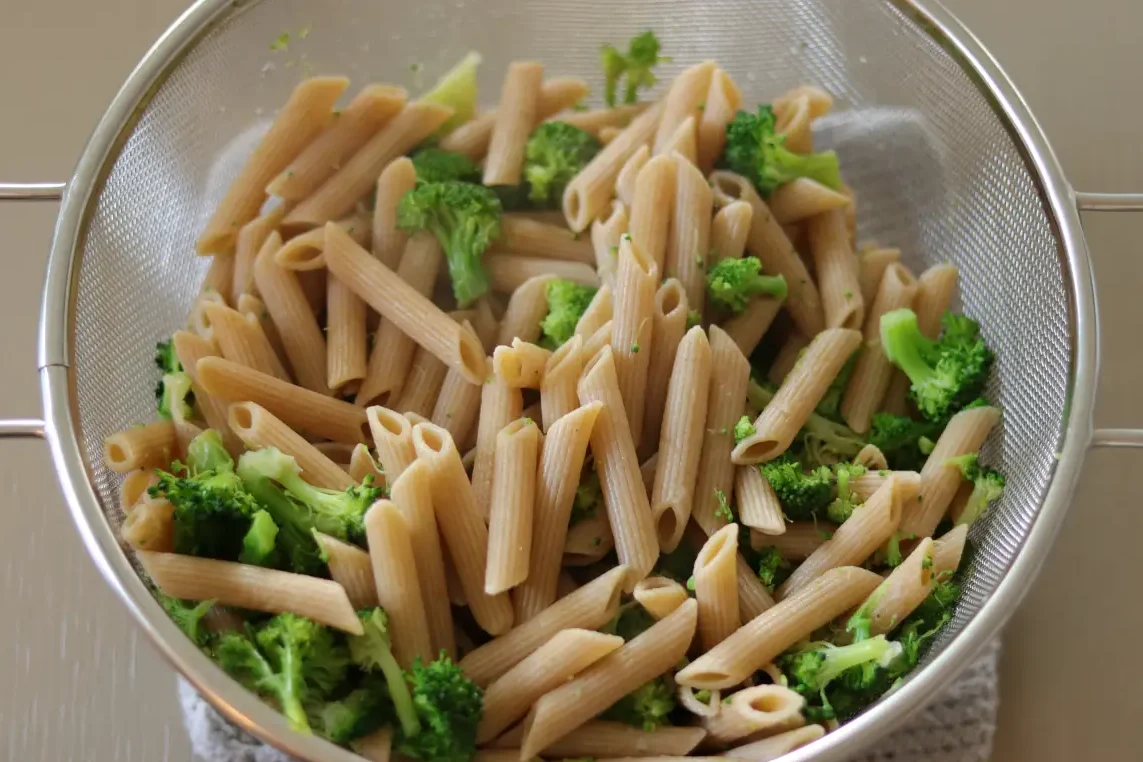 Pasta cooked with broccoli in a colander. 