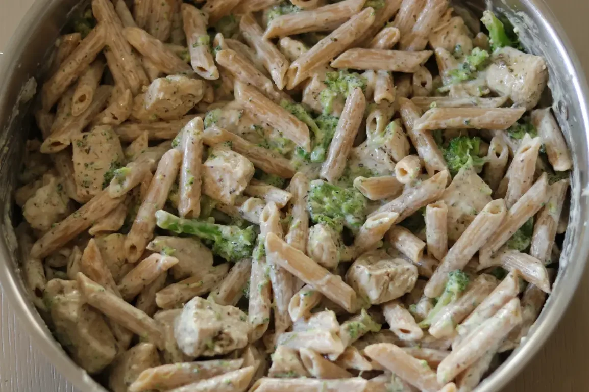 All of the ingredients for the chicken broccoli alfredo combined in a pan.