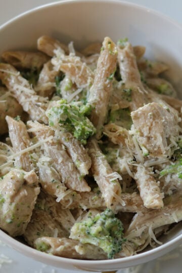 Chicken broccoli alfredo in a bowl topped with parmesan cheese.