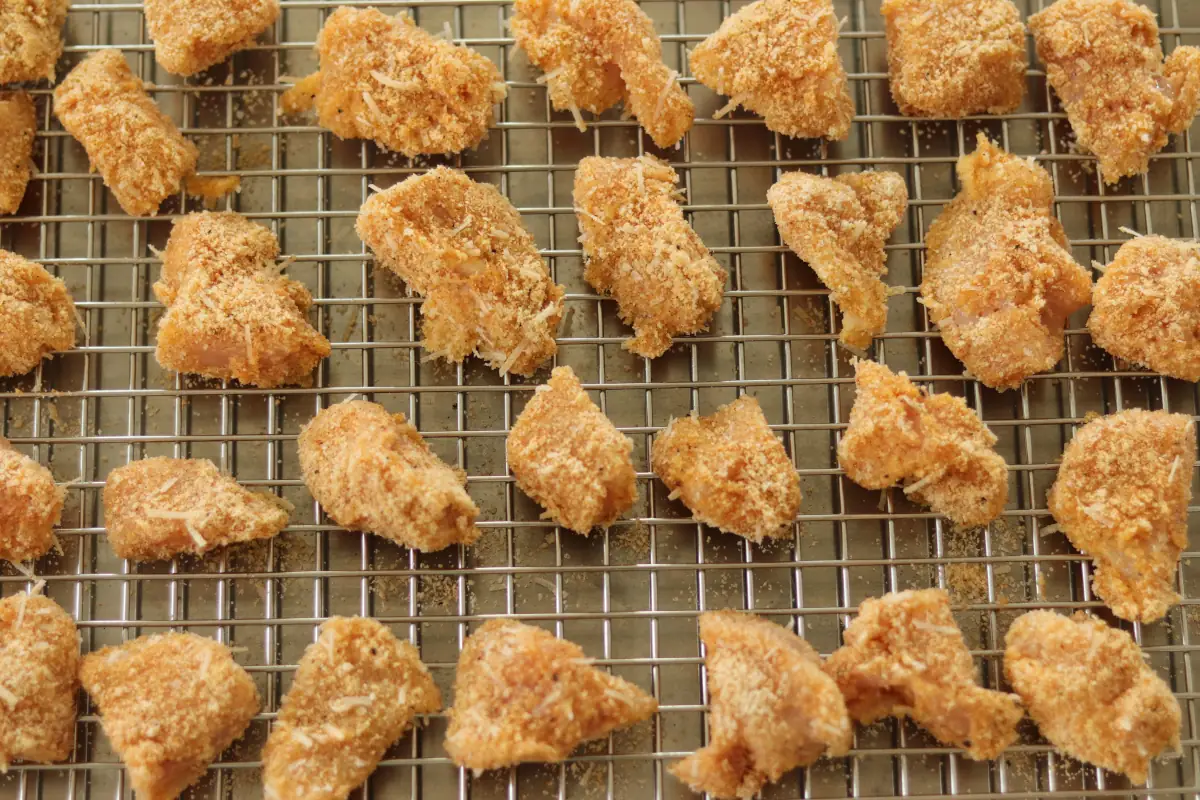Chicken nuggets on the baking sheet before they have been baked.