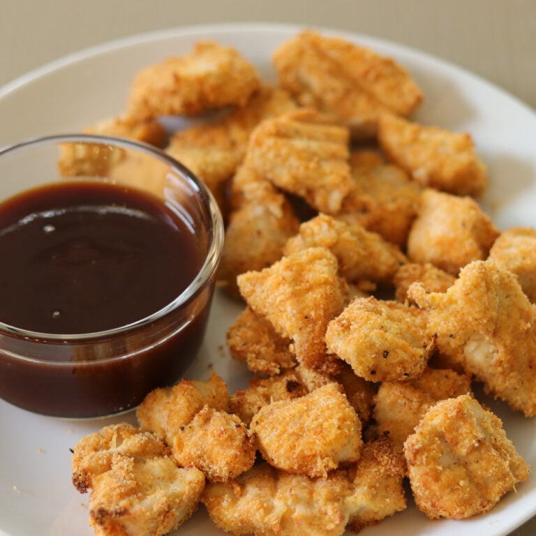 Gluten Free Chicken nuggets on a white plate next to dipping sauce.