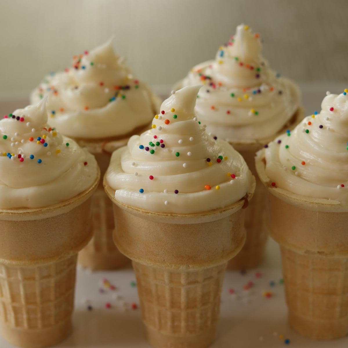 Ice cream cone cupcakes frosted and topped with sprinkles.