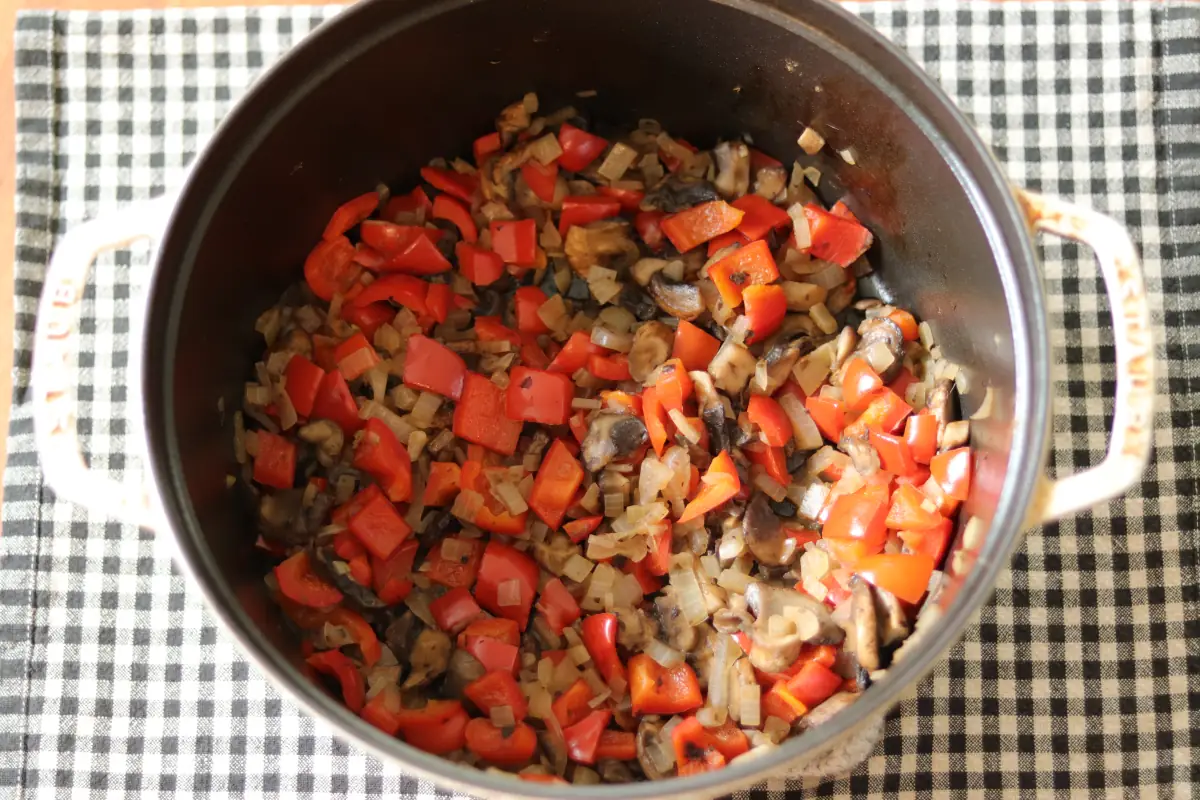 Cooked vegetables for low carb chili in a white dutch oven.