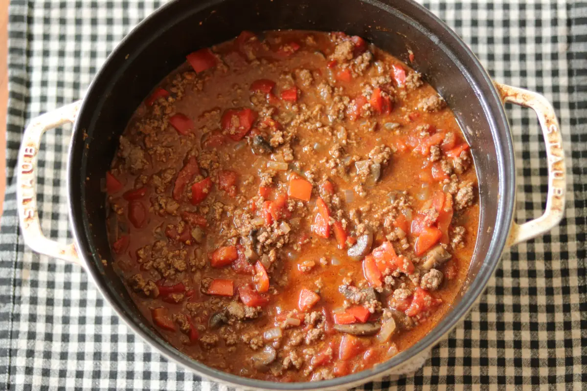 All of the ingredients for low carb chili combined in a white dutch oven.