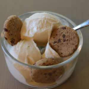 Scoops of ice cream in a bowl with chocolate chip cookies.