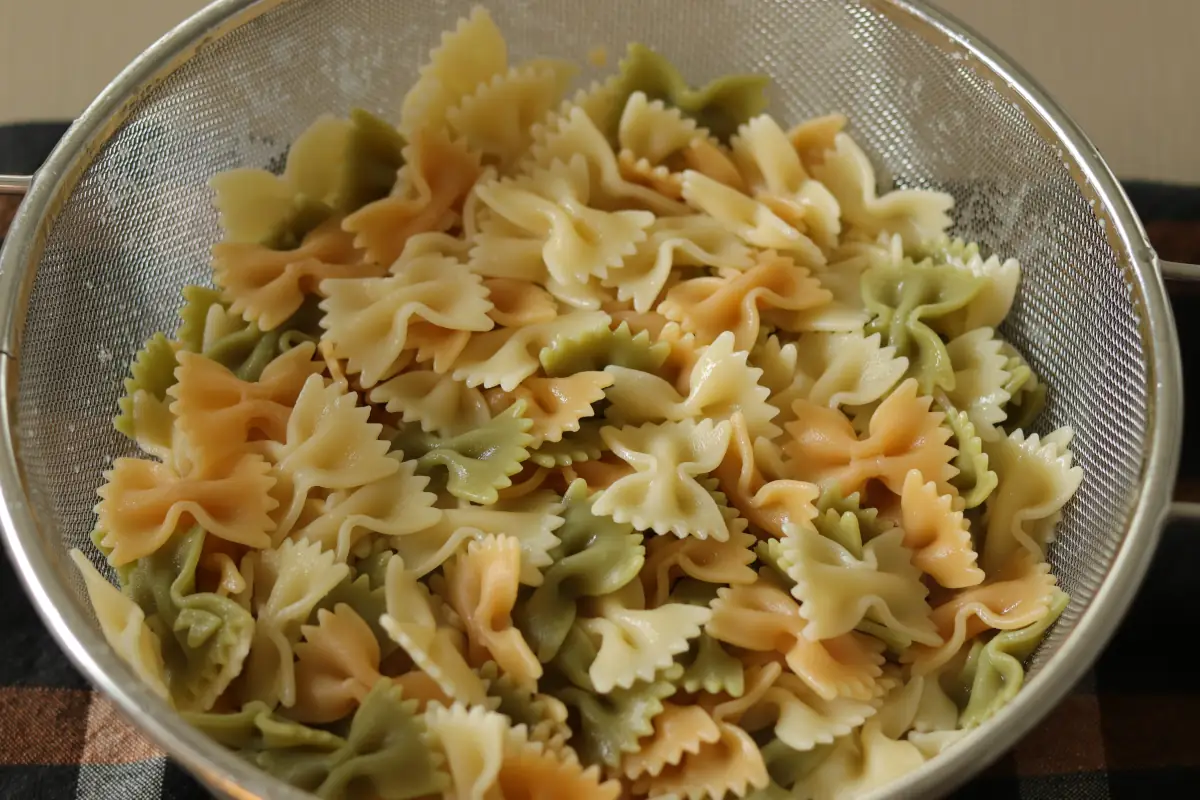 Bowtie pasta cooked in a colander.