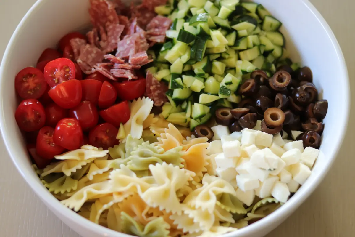 All of the ingredients for the pasta salad chopped in a bowl.